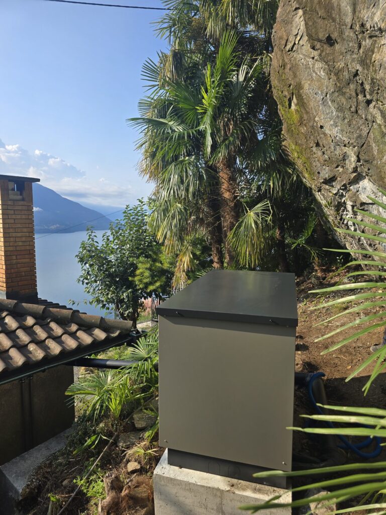 Luft-Wasser Sole-Wasser Wärmepumpe Vergleich – Aussengerät einer Luft-Wasser-Wärmepumpe an einem Haus in voralpiner Lage
