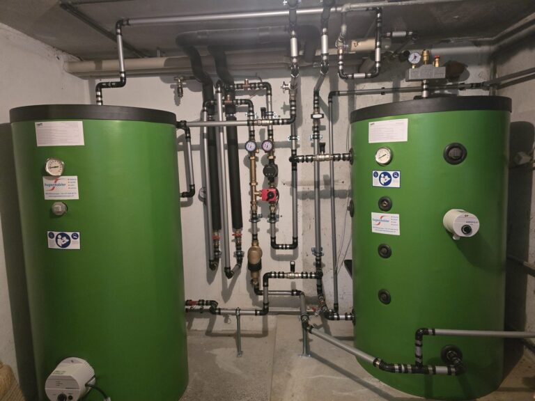 Zwei Pufferspeicher mit Verrohrung im Heizraum einer Luft/Wasser-Wärmepumpe in Uzwil